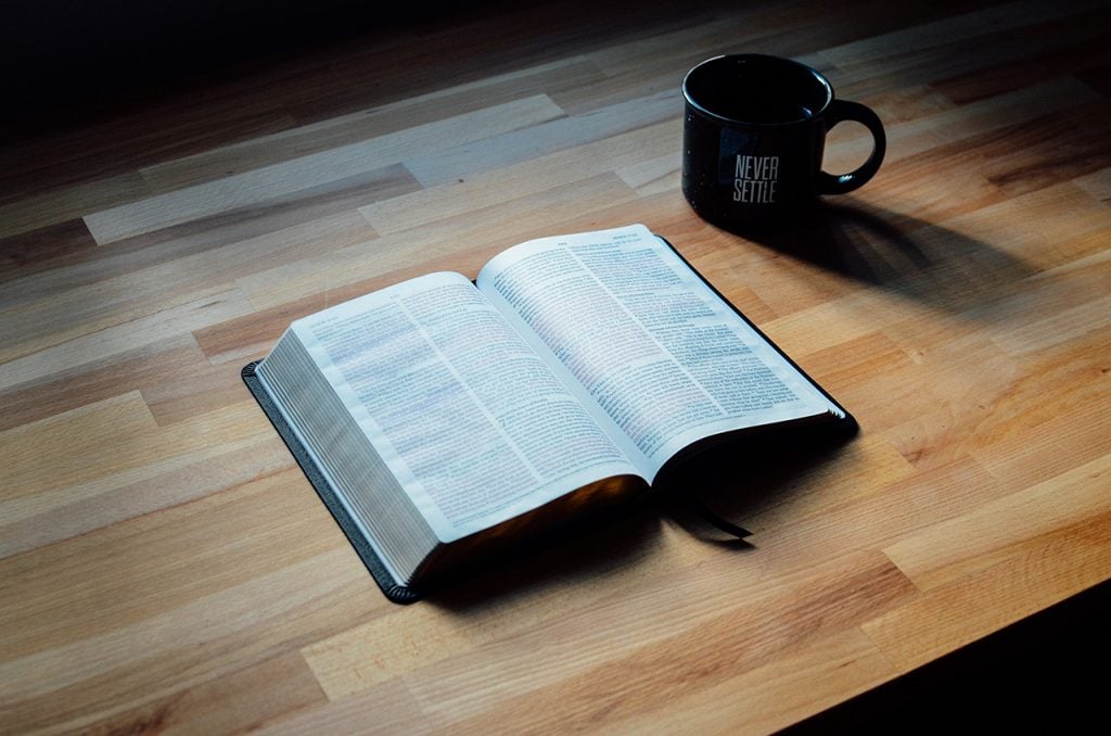 Open Bible and Coffee Mug on Table