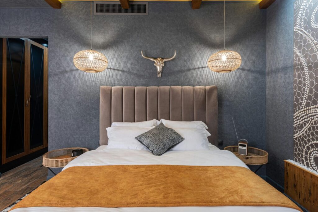 Stylish bedroom interior with cozy bed and artistic wall decor, perfect for relaxing.