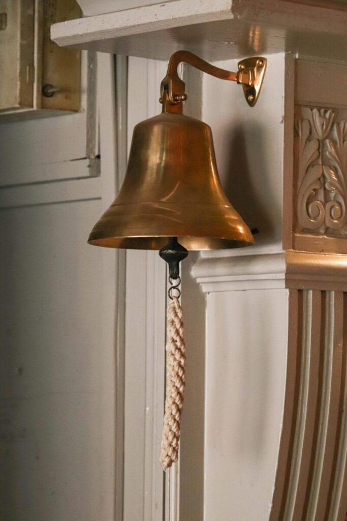Close-up of a vintage brass bell with a rope pull, evoking nostalgia.