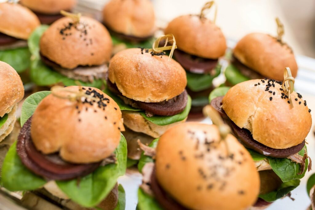 Delicious mini burgers with spinach and beetroot, perfect for parties or events, served on a decorative platter.