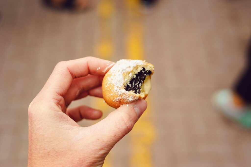 A person holding a half eaten doughnut in their hand