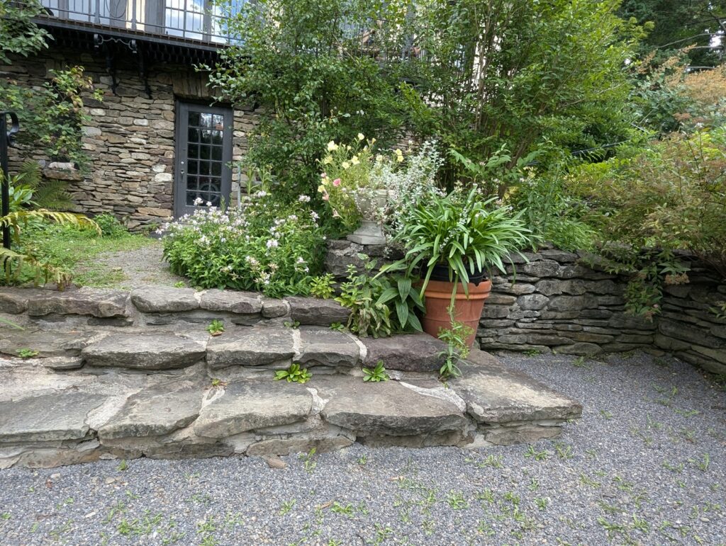 A stone house with a large garden in front of it